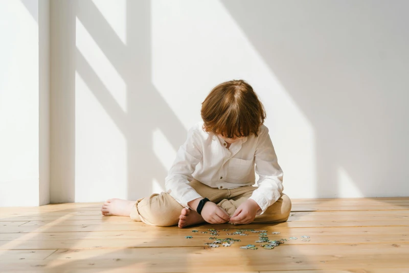 un enfant joue seul, ne nous montre pas son visage