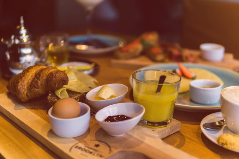 Un petit déjeuner complet avec viennoiserie, oeuf et jus d'orange